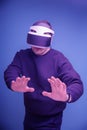 man plays with his hands raised in virtual reality glasses and stretches his arms out in front of him. Blue tinted paint Royalty Free Stock Photo