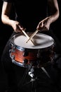 man plays musical percussion instrument with sticks closeup on a black background, a musical concept with the working drum,