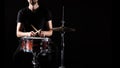 man plays musical percussion instrument with sticks closeup on a black background, a musical concept with the working drum, Royalty Free Stock Photo