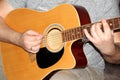 Man plays a six-stringed wooden guitar, musical concept, close-up