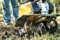 A man plowing a garden soil by motor cultivator bottom view Royalty Free Stock Photo