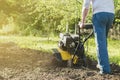 A man plowing a garden soil by motor cultivator perspective view Royalty Free Stock Photo