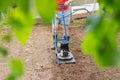 Man plows the ground with an electric cultivator