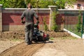 Man plows the ground with a motor cultivator. A farmer ploughs the soil using a petrol cultivator