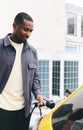 Man Plugging In Electric Car Outside Office In Car Park Charging