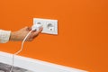 Man plugging phone adapter into a electrical outlet Royalty Free Stock Photo