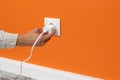 Man plugging phone adapter into a electrical outlet Royalty Free Stock Photo