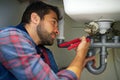 Man, plumber and wrench with pipe for repair, service or fix in home maintenance or indoor leak. Young male person Royalty Free Stock Photo