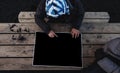 A man pointing finger on empty black paper, Travelers planning for a vacation trip on wooden table, top view