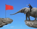 Man with pointing finger riding elephant toward red flag Royalty Free Stock Photo
