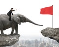 Man with pointing finger riding elephant toward red flag Royalty Free Stock Photo