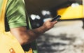 Man pointing finger on screen smartphone on background yellow taxi, tourist hipster using in hands mobile phone, person connect wi Royalty Free Stock Photo