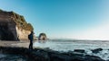 Man pointing with finger at what used to be Elephant rock, New Plymouth, New Zealand in 2020