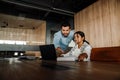 Man pointing at laptop and discussing something with his colleague while standing in office Royalty Free Stock Photo