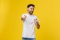Man pointing showing copy space isolated on yellow background. Casual handsome Caucasian young man. Royalty Free Stock Photo