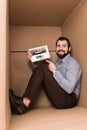 cheerful handsome man pointing at tablet with photo stock website while sitting