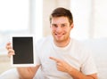 Man pointing at tablet pc at home