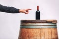 Man pointing to a bottle of red wine on an oak barrel Royalty Free Stock Photo