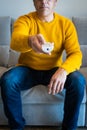 Man pointing with tv`s remote control towards camera from sofa Royalty Free Stock Photo