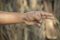 A man pointing with two fingers and the background behind it blurred