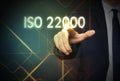 Man pointing at virtual screen with text ISO 22000, closeup