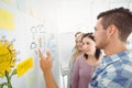 Man pointing at wall with sticky notes and drawings Royalty Free Stock Photo