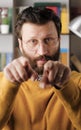 Man points his finger to you. Serious frowning bearded man with glasses looking at camera and points his finger in Royalty Free Stock Photo