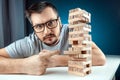 The man points to the Column of the game of jenga. The concept of a mortgage, investment risks, economic crisis, economic