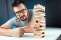 The man points to the Column of the game of jenga. The concept of a mortgage, investment risks, economic crisis, economic