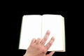 A man holds an open book in his hand on a black background. Royalty Free Stock Photo