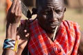 Man poking knife through hole in earlobe