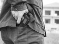 A man, policeman or robber, gangster concealing his gun behind his back