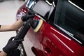 Man polishing car paint varnish in detailing studio Royalty Free Stock Photo