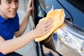 A man polishing cleaning car with microfiber cloth