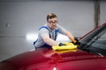 Man polishing cleaning car with microfiber cloth, detailing or valeting concept. Washing professional wiping car bonnet. Royalty Free Stock Photo