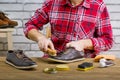 Man polishing leather shoes with brush on wooden table of workplace. Royalty Free Stock Photo