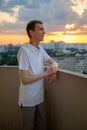 Man in polo shirt standing on balcony in dusk Royalty Free Stock Photo