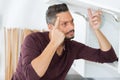 Man pondering how to repair cupboard Royalty Free Stock Photo