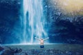Man in pool at the base of large waterfall Royalty Free Stock Photo