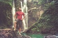 Man in pool at the base of large waterfall Royalty Free Stock Photo