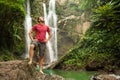 Man in pool at the base of large waterfall Royalty Free Stock Photo