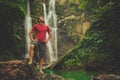 Man in pool at the base of large waterfall Royalty Free Stock Photo
