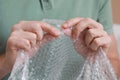 Man popping bubble wrap, closeup view. Stress relief Royalty Free Stock Photo
