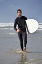 Man, portrait and beach on water with surfboard for waves, exercise or outdoor hobby in fitness, surfing or practice Royalty Free Stock Photo