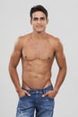 Man, portrait and confident in studio for fashion, smiling and bodybuilder in jeans for style. Male person, shirtless