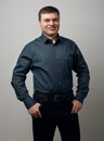 Man portrait dressed in dark shirt and black pants over gray background