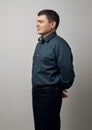 Man portrait dressed in dark shirt and black pants over gray background Royalty Free Stock Photo