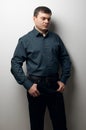 Man portrait dressed in dark shirt and black pants over gray background Royalty Free Stock Photo