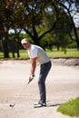 Man, portrait and golfer with club for stroke, point or strike in sand pit by grass field in nature. Male person or Royalty Free Stock Photo