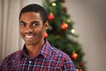 Man, portrait and happy in home on christmas for celebration, holiday and festive spirit in living room. African person Royalty Free Stock Photo